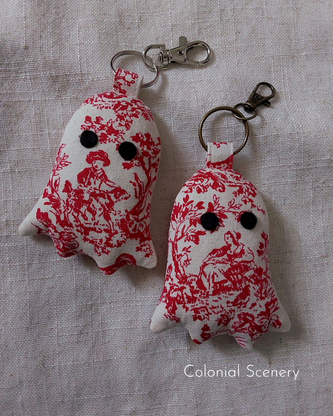 front view of colonial toile cotton upcycled ghost keychains laying flat