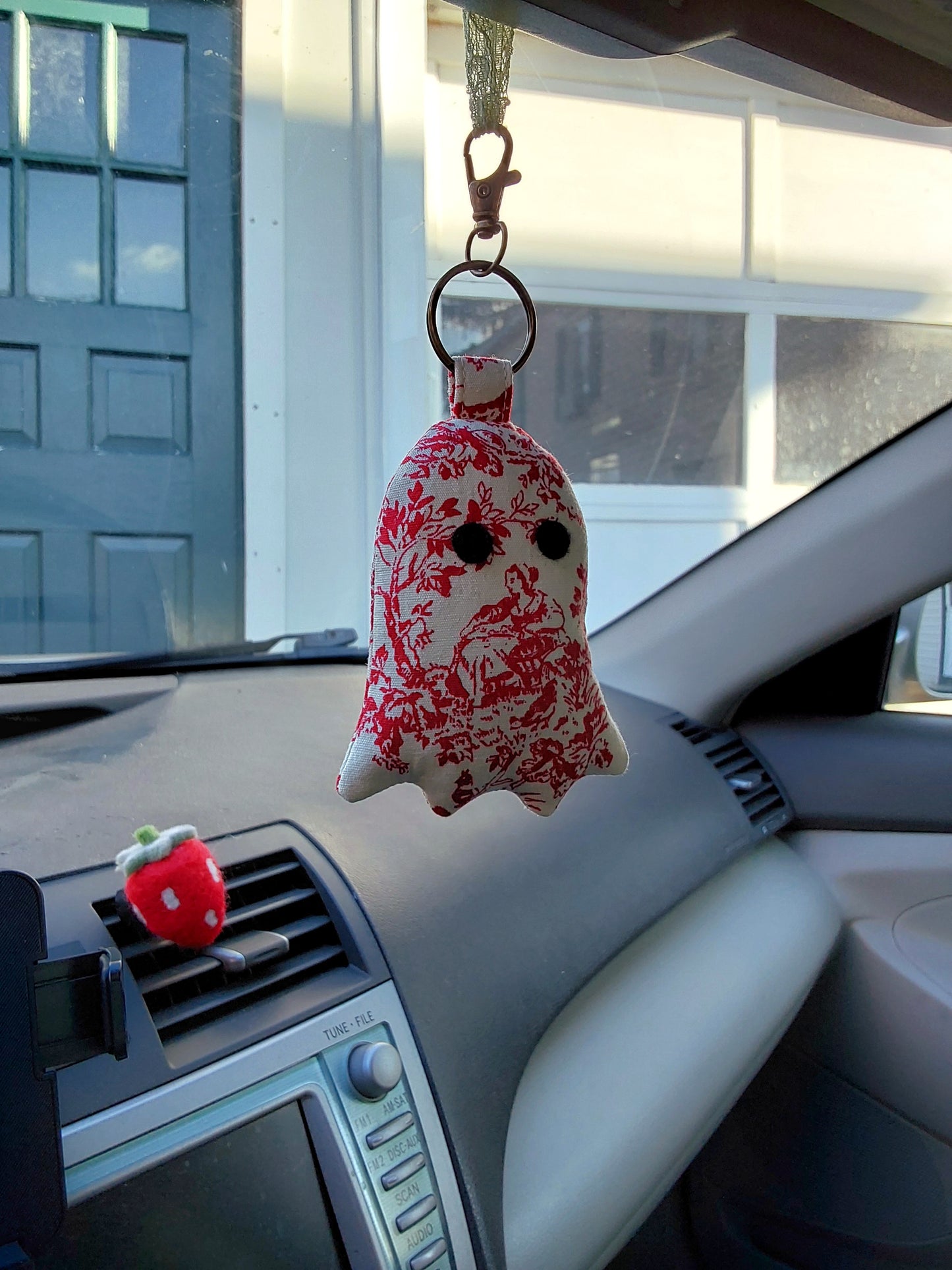 front view of colonial toile cotton upcycled ghost keychain displayed in rear view mirror of car