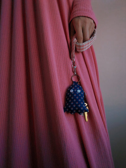 front view of calico navy cotton upcycled ghost keychain displayed on keys held by model