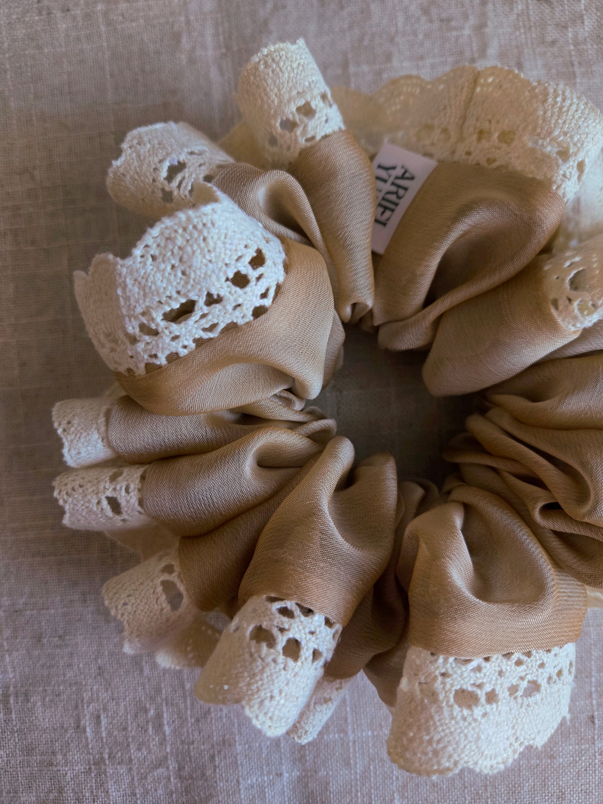 close up of beige lace upcycled scrunchie laying down