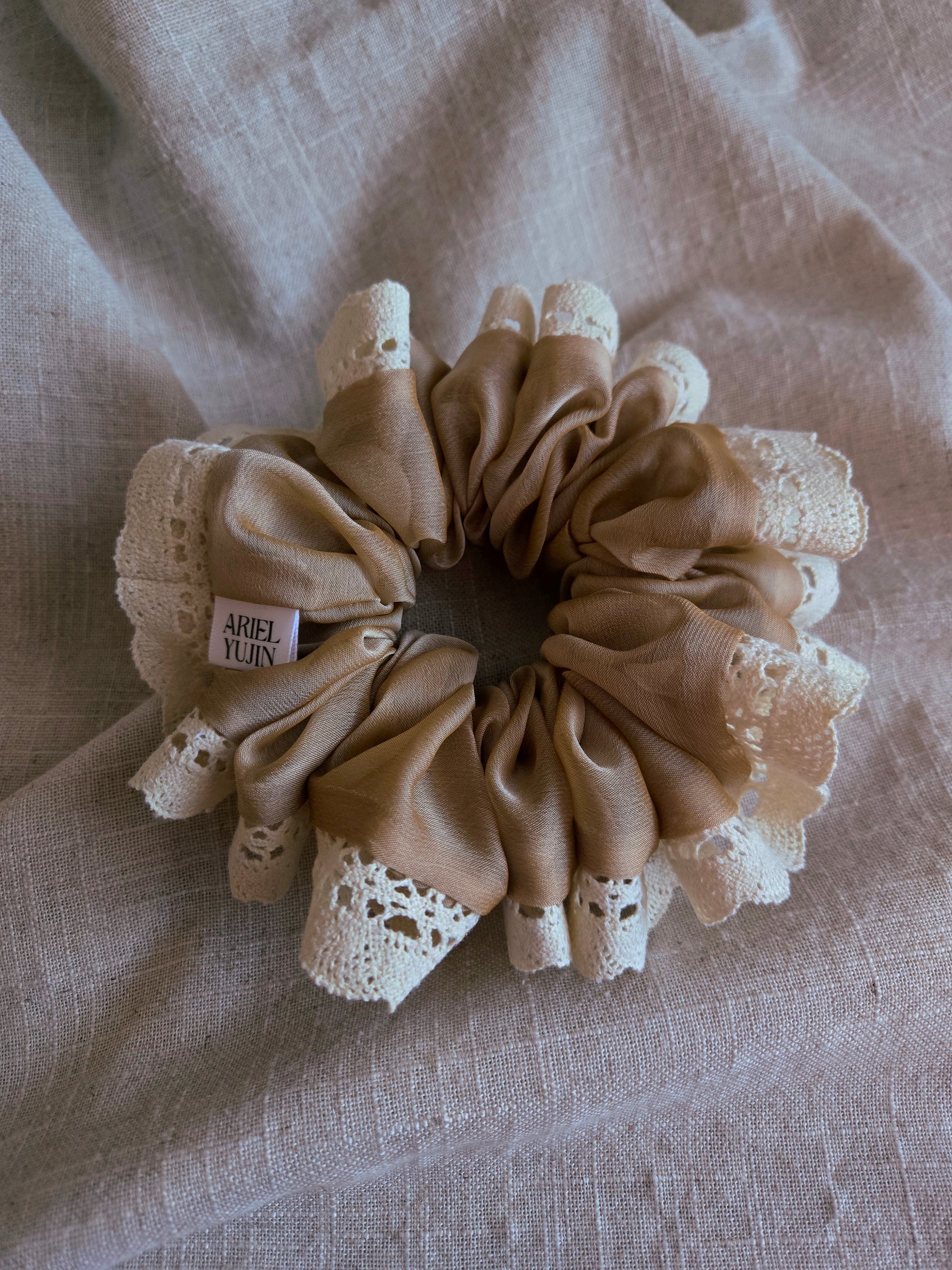 front view of beige lace upcycled scrunchie laying down