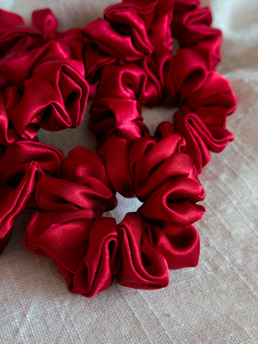 front view of red satin upcycled scrunchies laying down