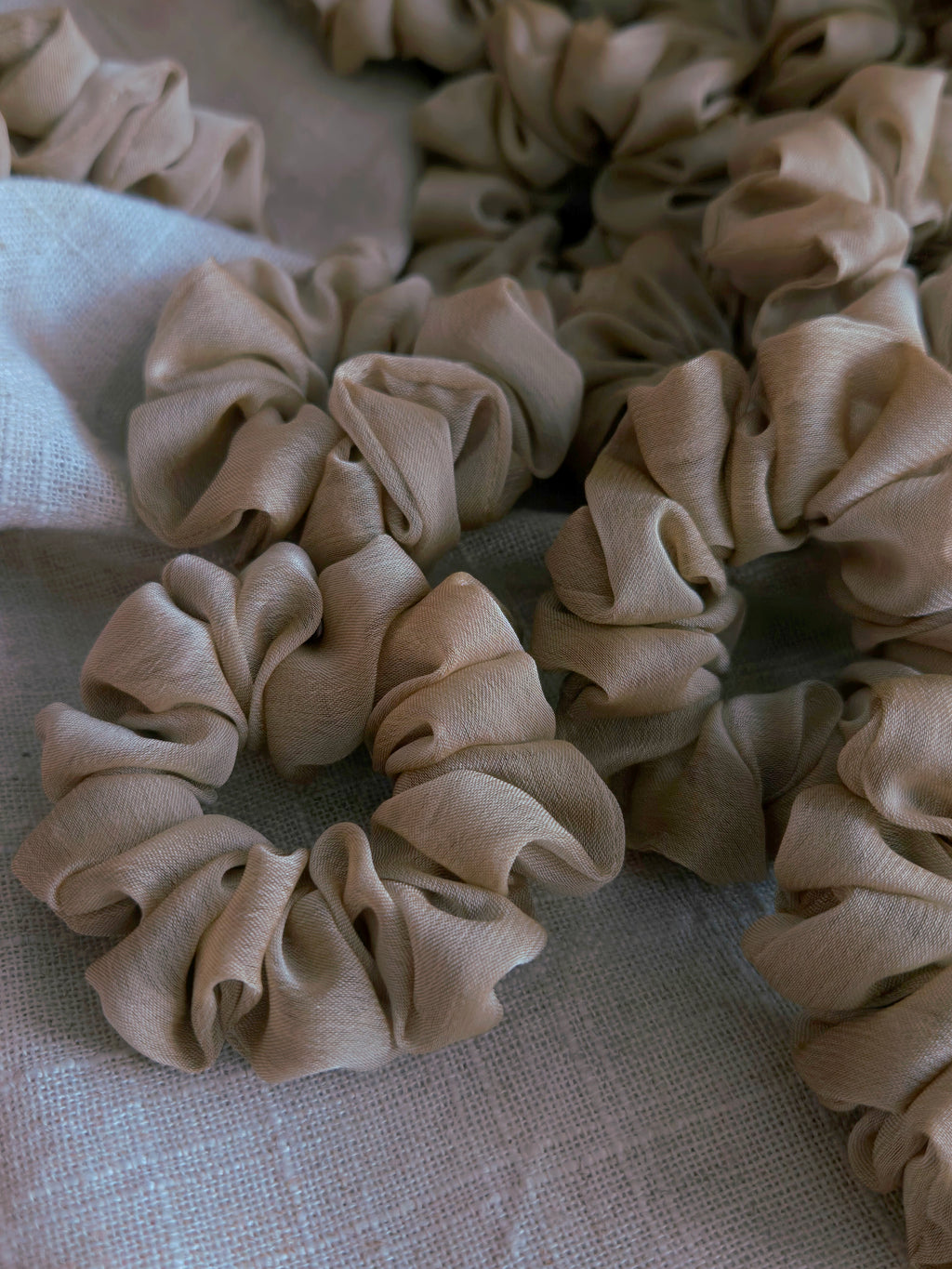 close up of beige organza upcycled scrunchie laying down