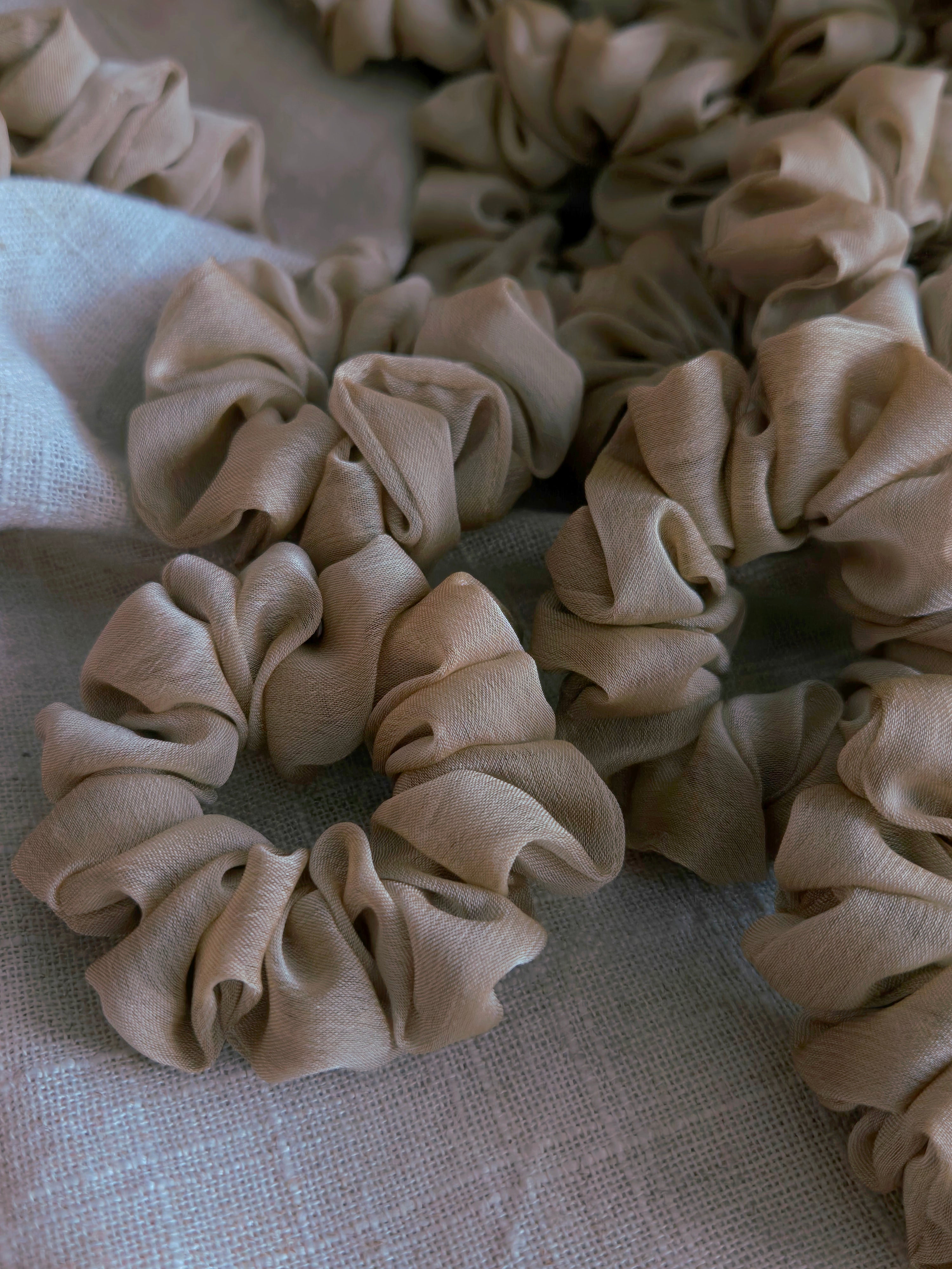 close up of beige organza upcycled scrunchie laying down