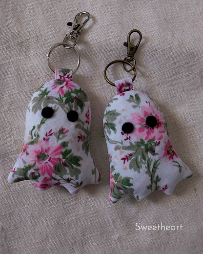 front view of pink flowers white cotton upcycled ghost keychains laying flat