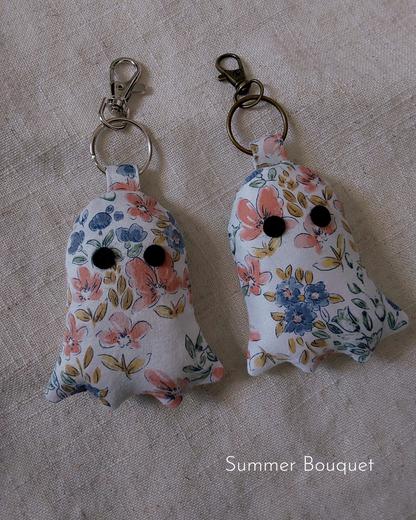 front view of floral white cotton upcycled ghost keychains laying flat