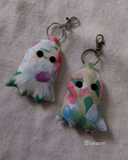 front view of colorful flowers cotton upcycled ghost keychains laying flat