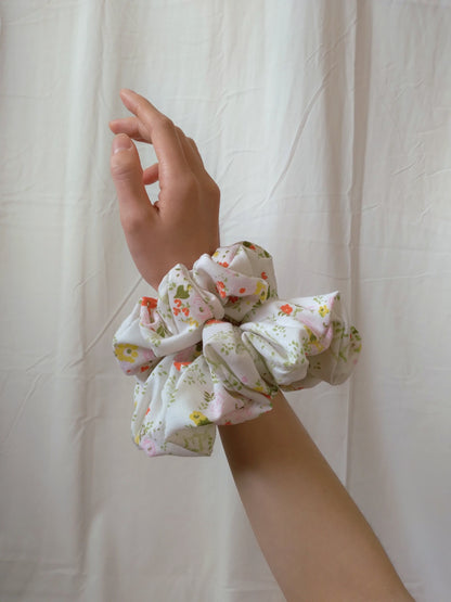 side view of floral white cotton upcycled scrunchies on wrist size comparison