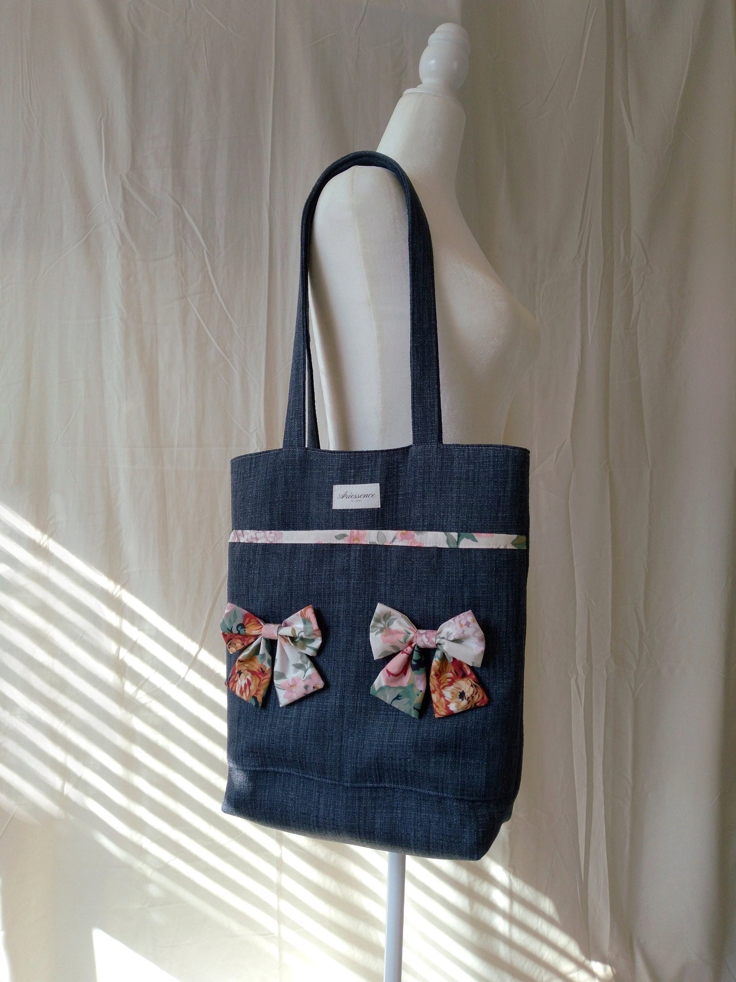 front view of cotton bow navy upcycled tote bag on mannequin