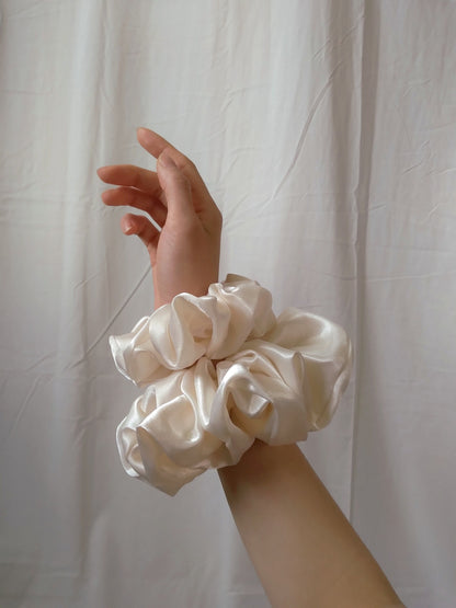 side view of ivory satin upcycled scrunchies on wrist