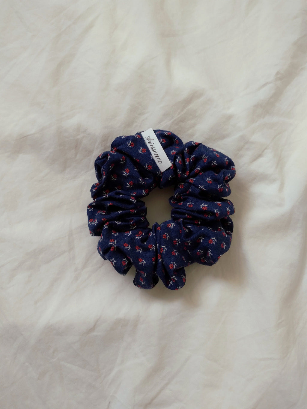 front view of calico navy cotton upcycled scrunchies laying down