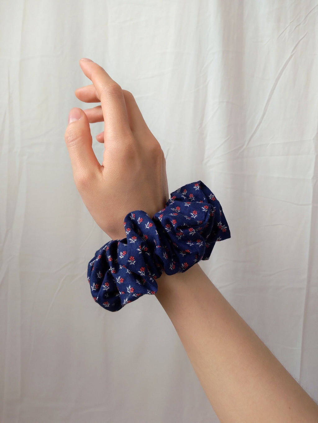 side view of calico navy cotton upcycled scrunchie on wrist