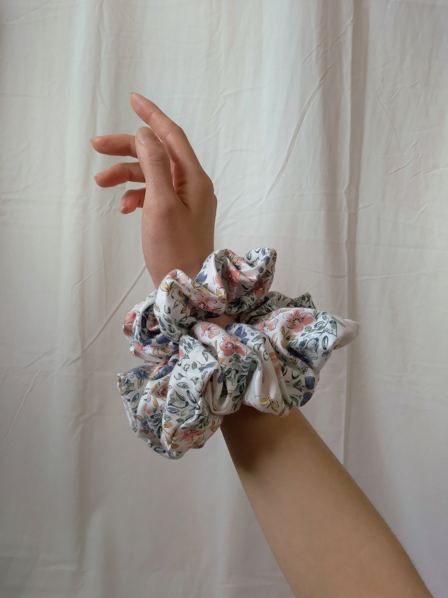 side view of floral cotton upcycled scrunchies on wrist size comparison