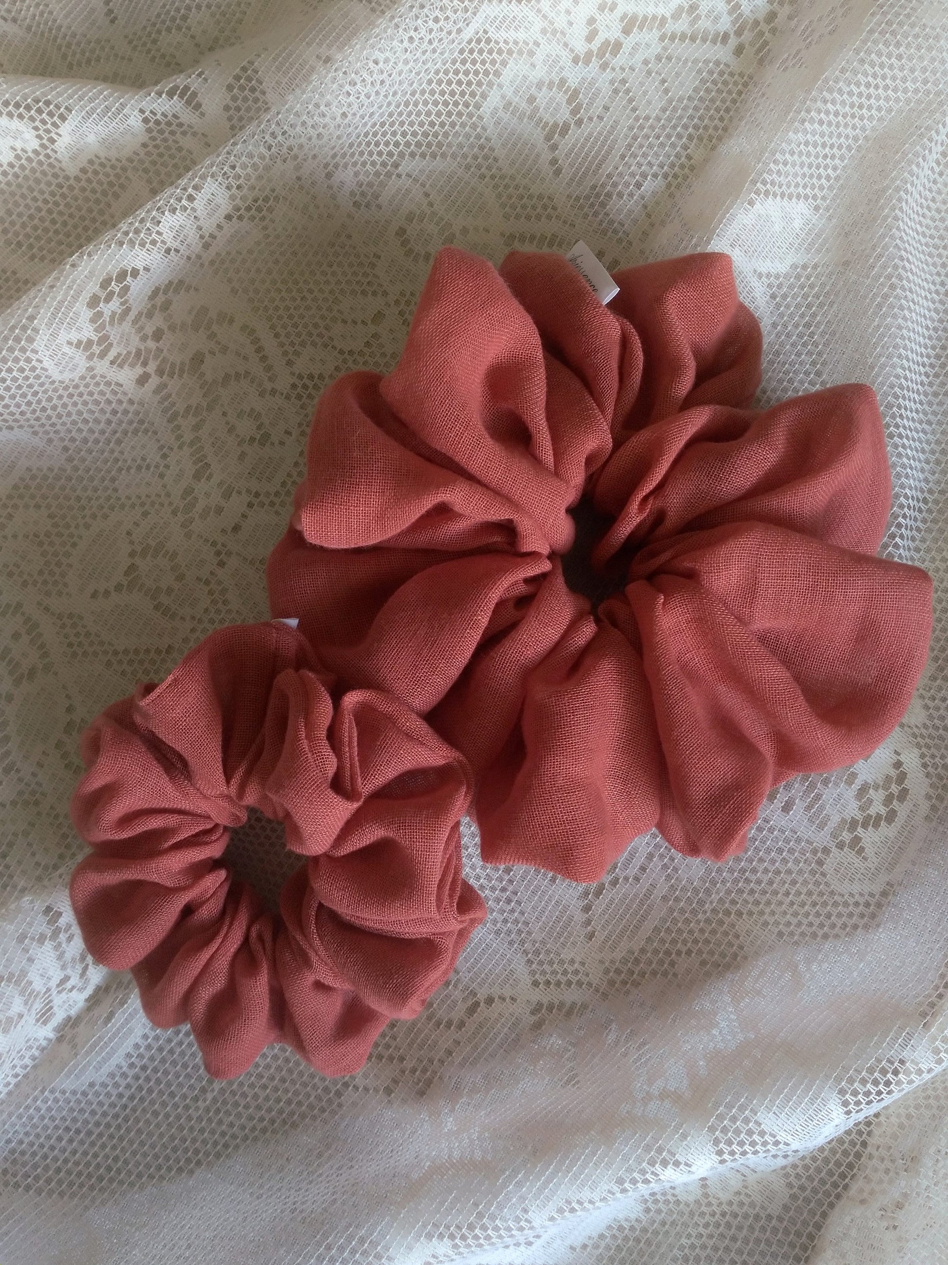 front view of terracotta linen upcycled scrunchies laying down size comparison