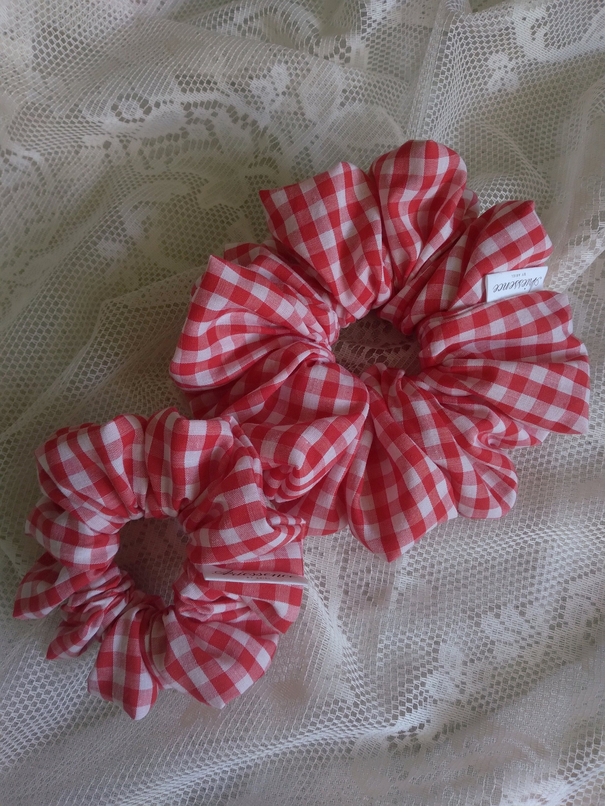 front view of red gingham cotton upcycled scrunchies laying down size comparison