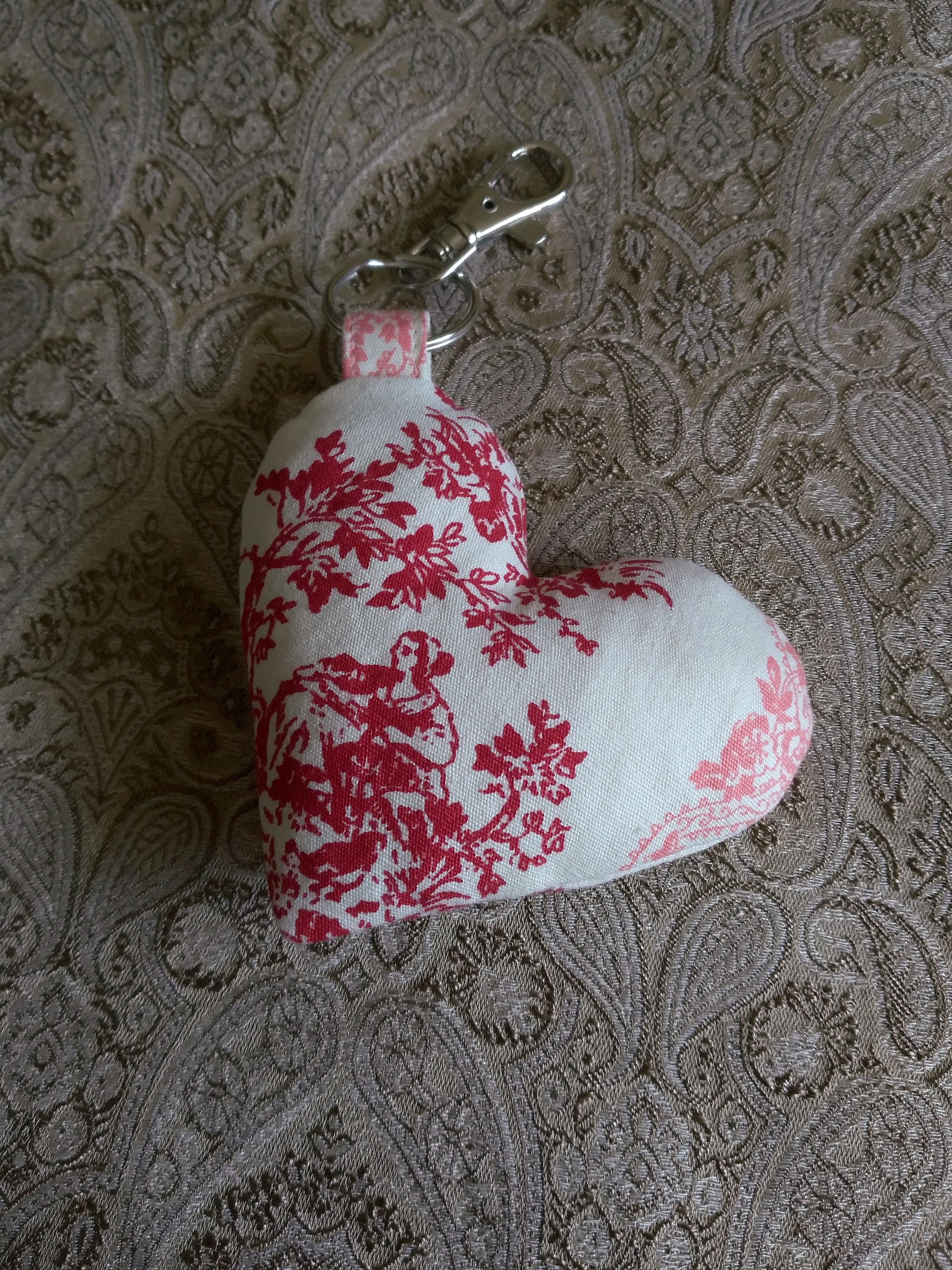 front view of colonial toile cotton upcycled heart keychain laying flat