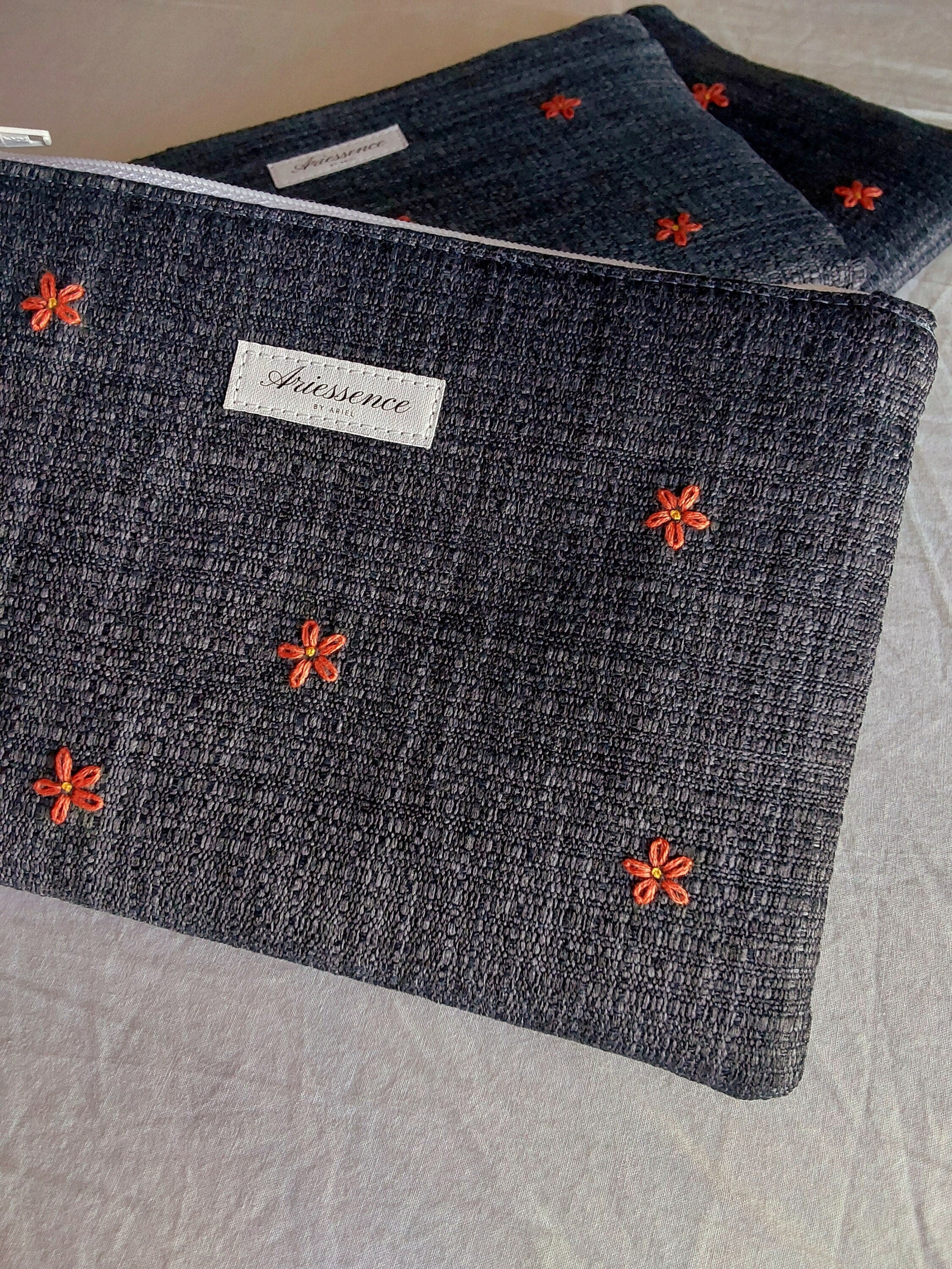 close up of hand embroidered daisy upcycled pouch