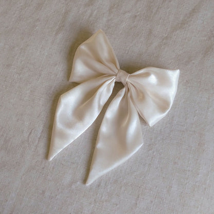 front view of ivory satin upcycled hair bow laying flat