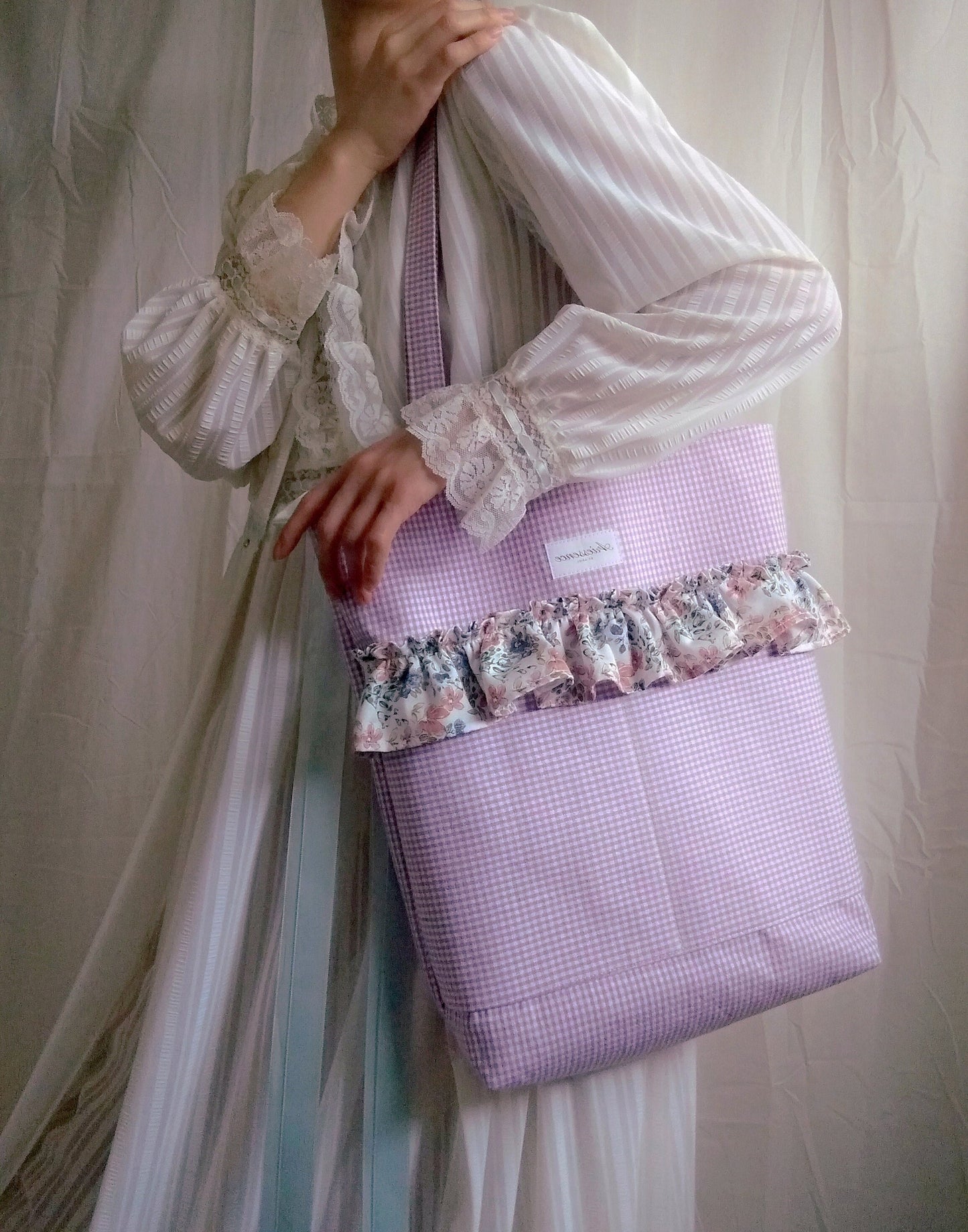 front view of purple gingham ruffle tote bag on model