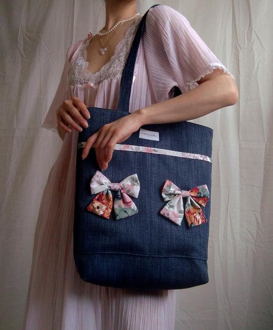 front view of cotton bow navy upcycled tote bag on model