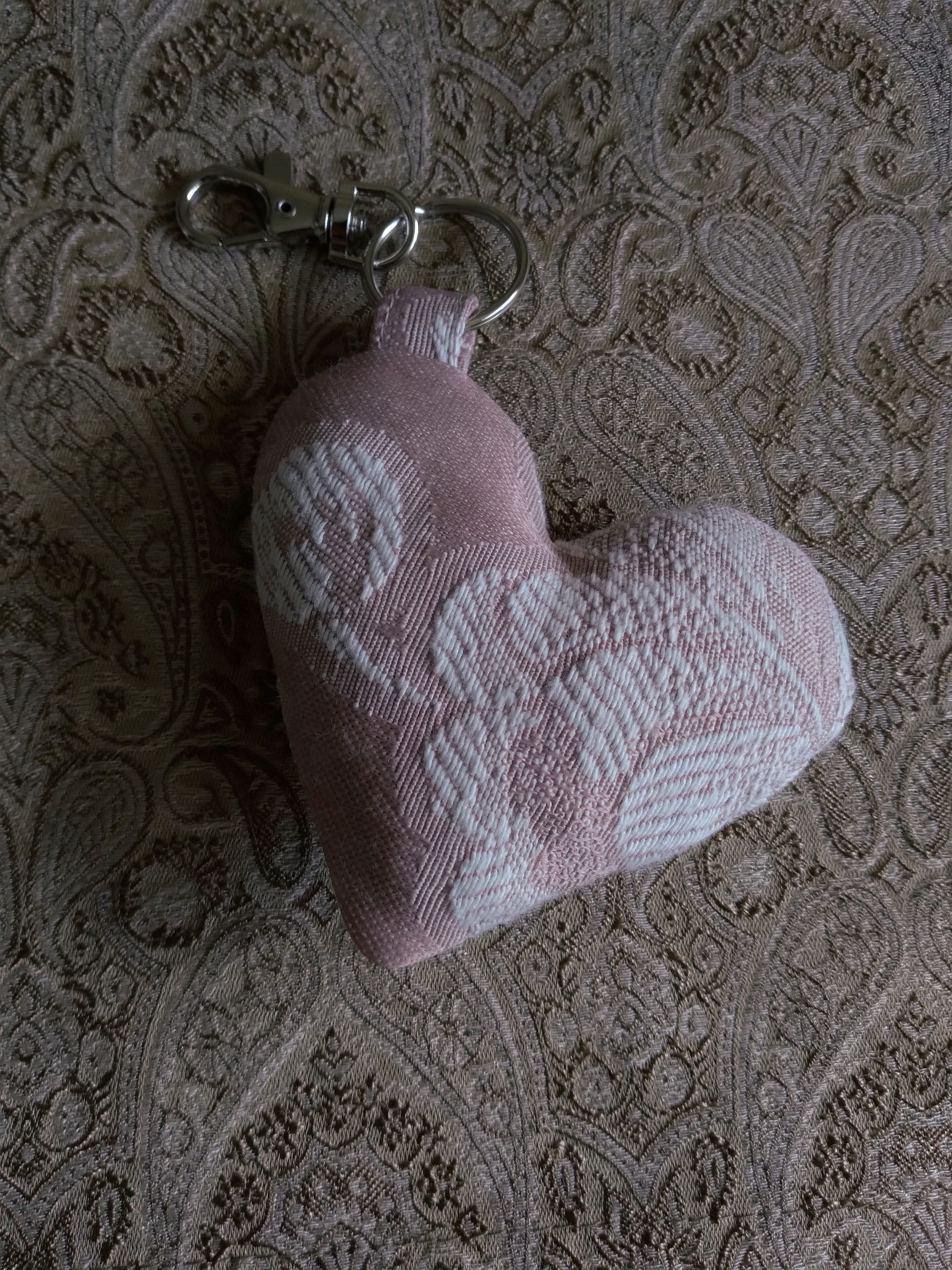 front view of pink jacquard upcycled heart keychain laying flat