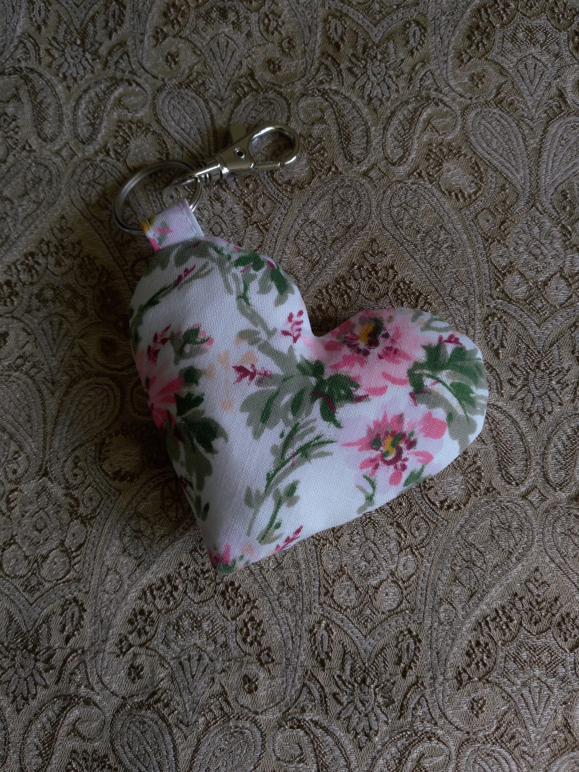 front view of pink florals white upcycled heart keychain laying flat