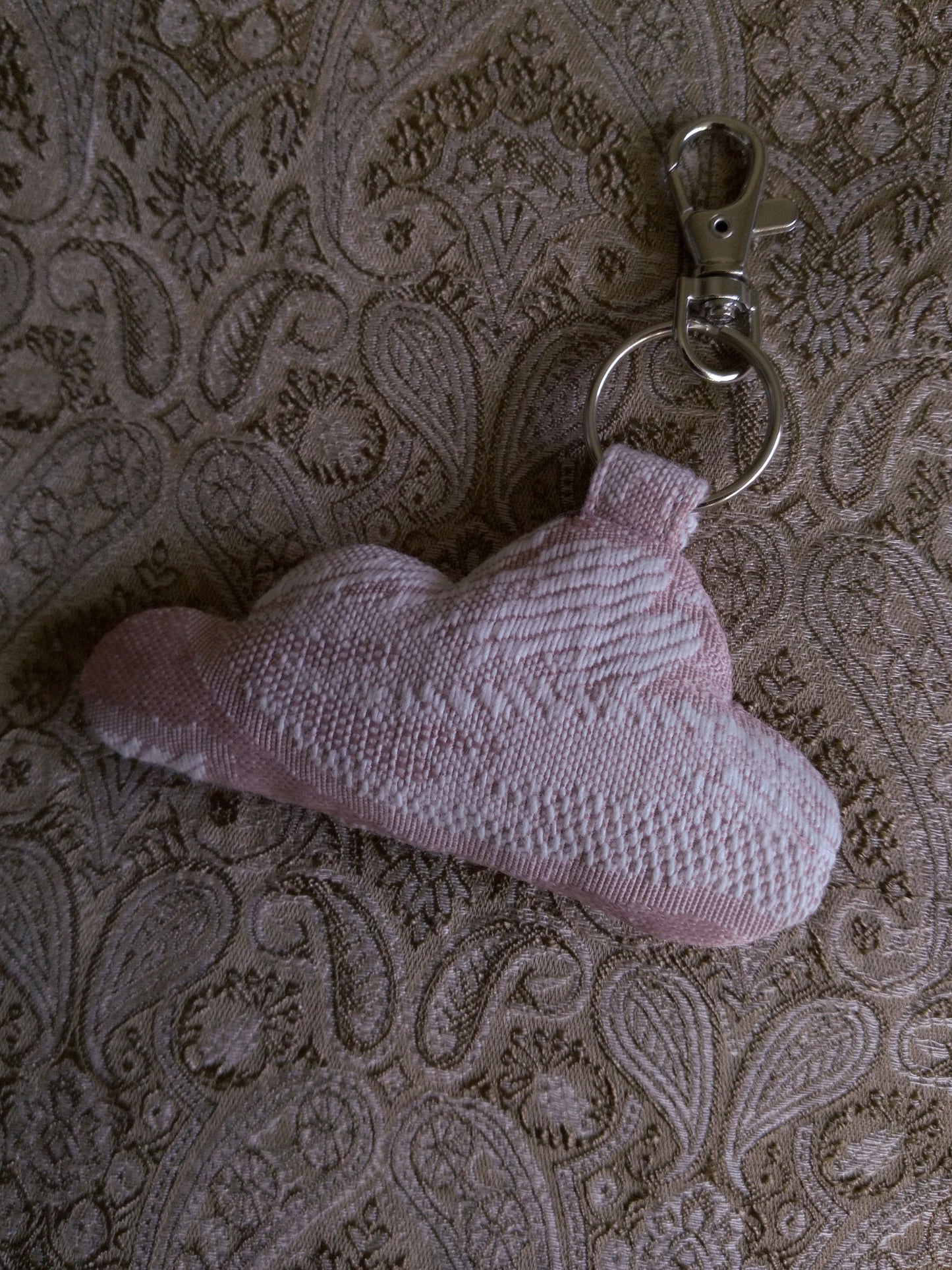 front view of pink jacquard upcycled cloud keychain laying flat