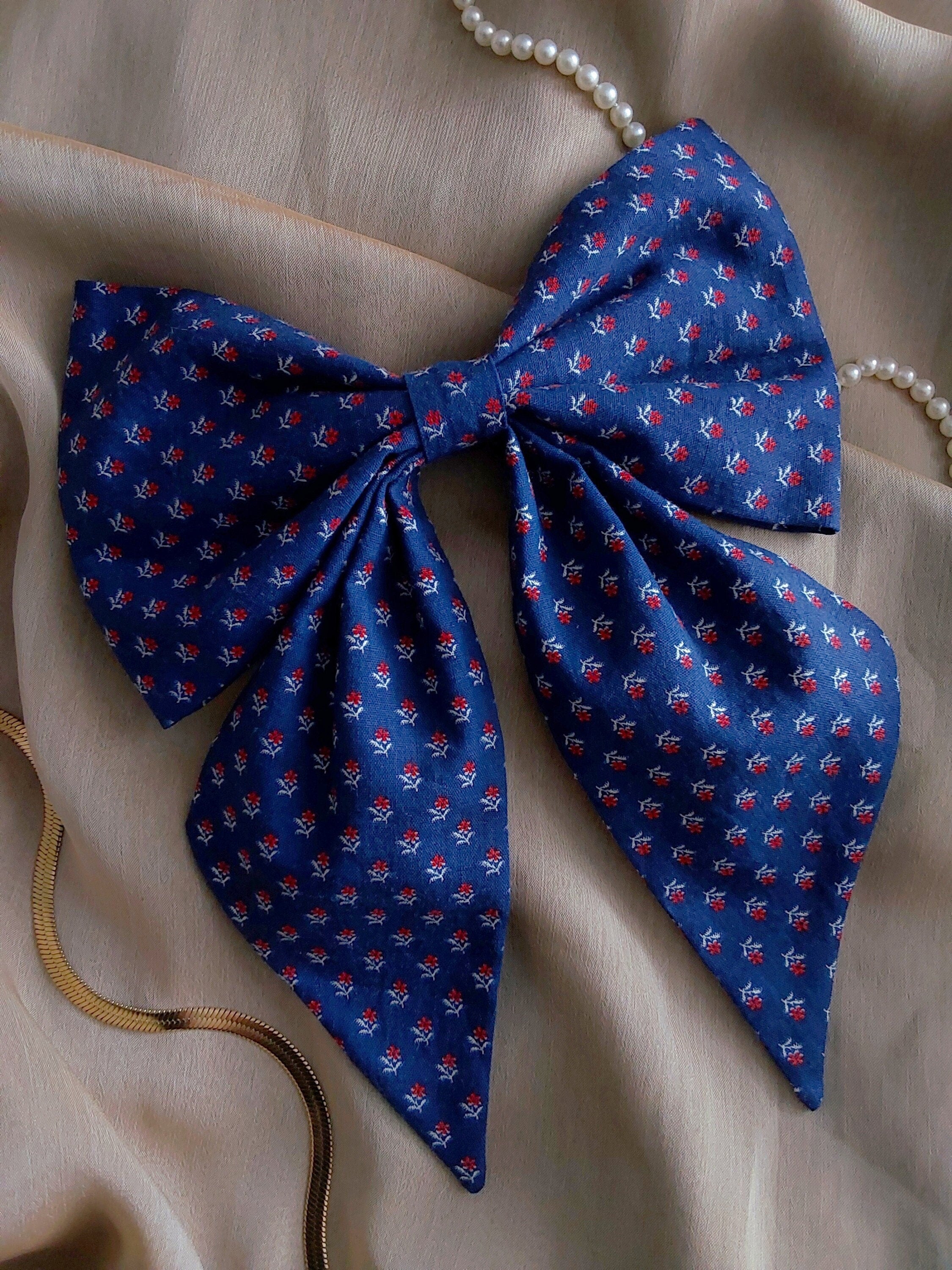 front view of calico navy cotton upcycled hair bow laying flat