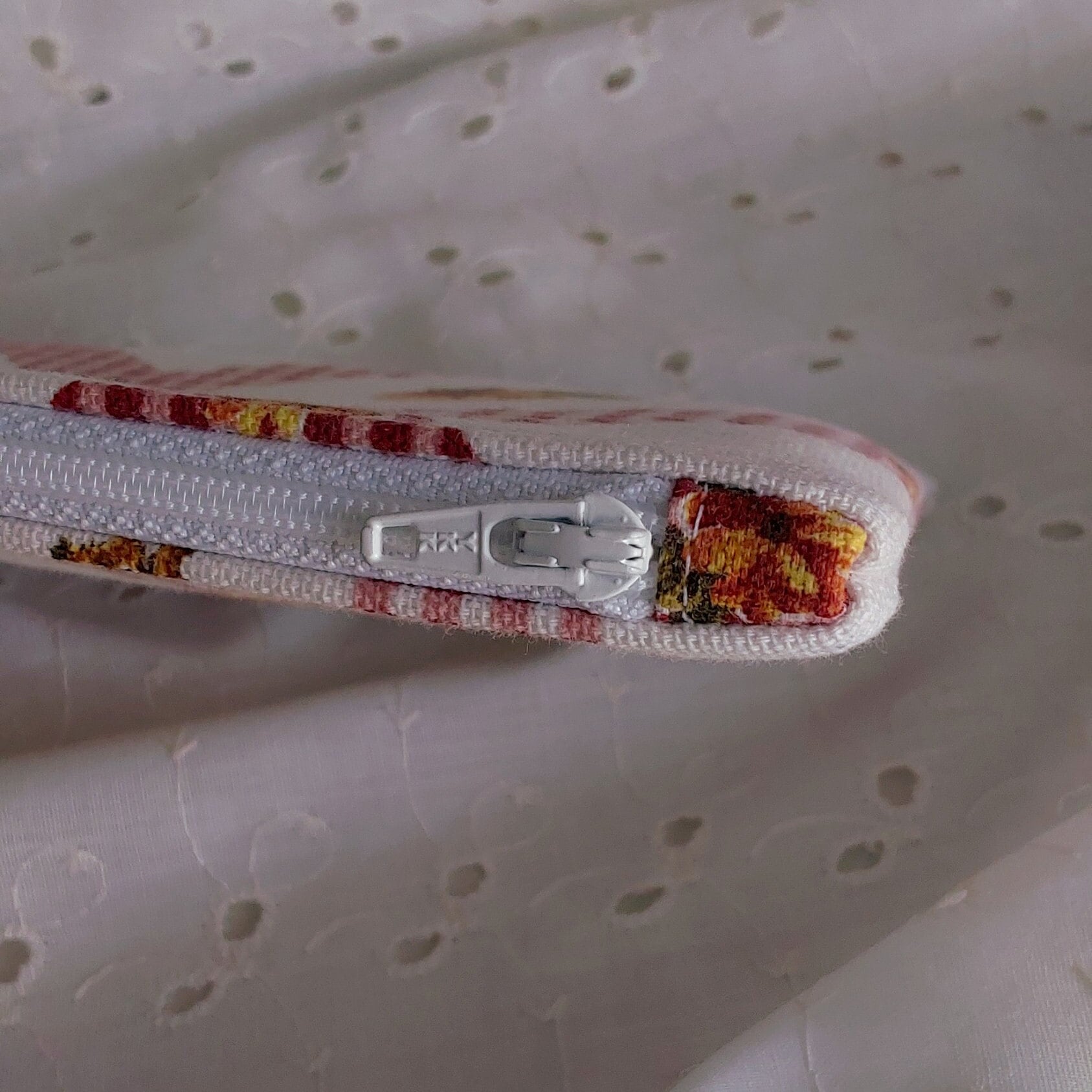 close up of zipper on rooster floral gingham red white cotton upcycled pouch