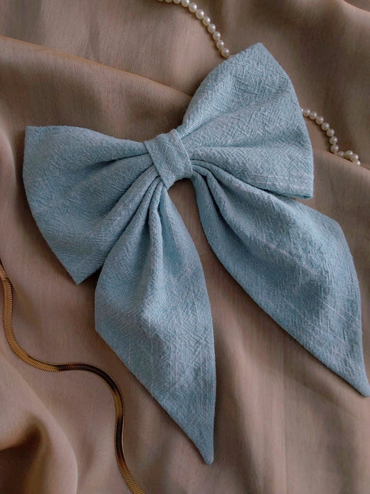 front view of light blue cotton upcycled hair bow laying flat