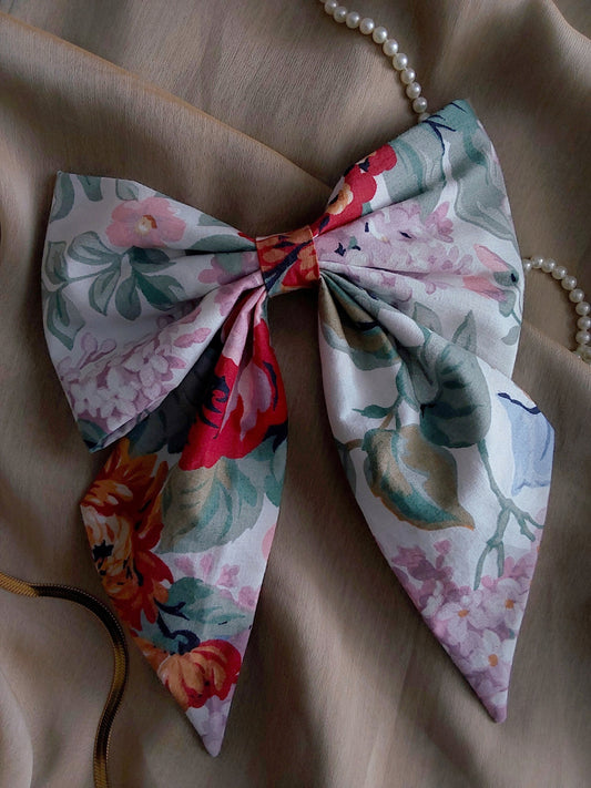 front view of floral cream cotton upcycled hair bow laying flat